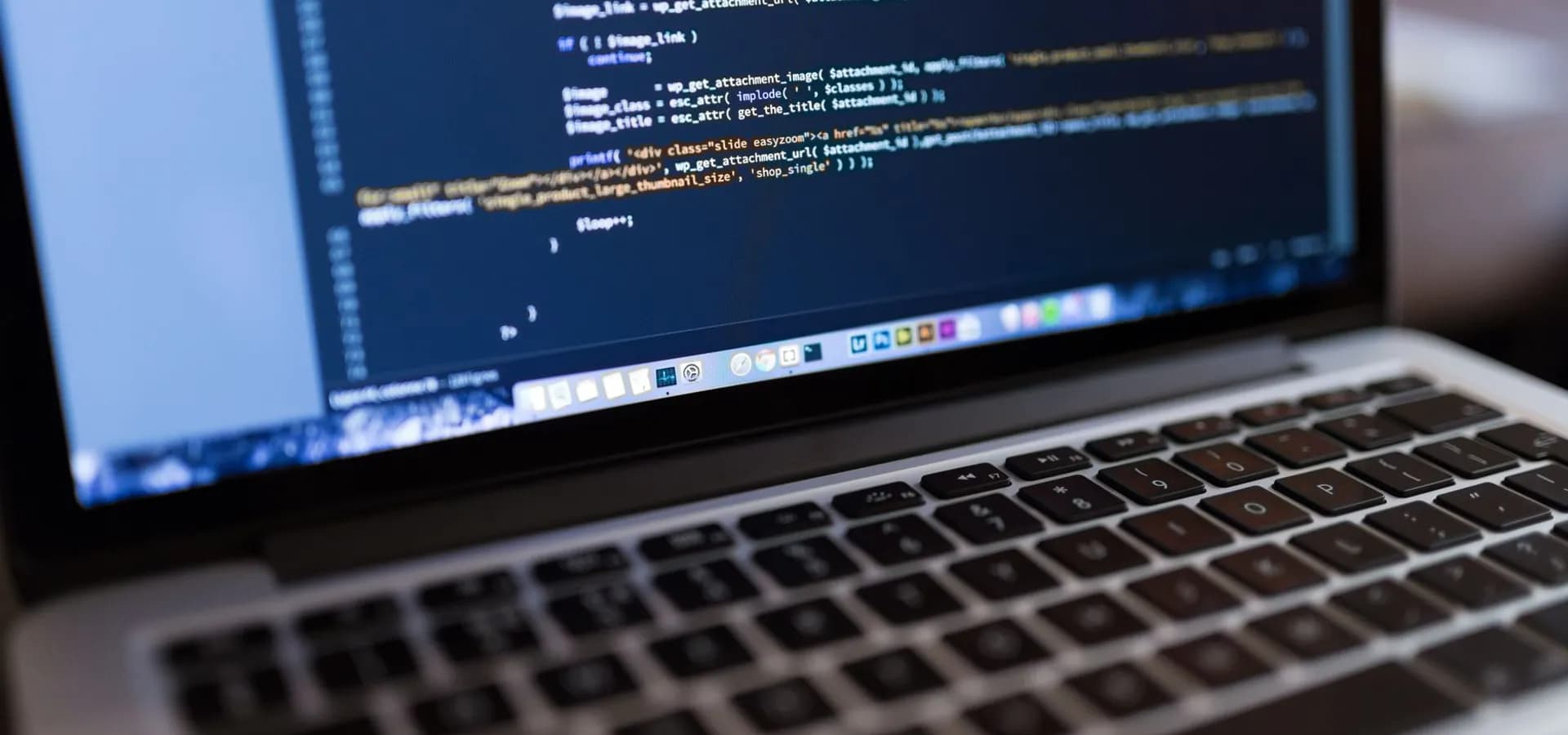 računalo s prikazanim kodom web-stranice na stolu u uredu